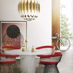 Jedálenský mramorový stôl, dizajnové stoličky a nadrozmerné zlaté svietidlo visiace nad stolom