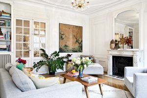 Obývačka zariadená v retro modernom štýle, s drevenými parketami, kozubom so štukovanou výzdobou a veľkým zrkadlom. V interiéri sa kombinuje azijský štýl s historickým a retro štýlom.