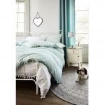 Spálňa s vintage kovovou posteľou, pastelovými farbami a komodou