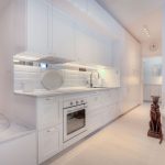 Moderná biela kuchyňa s prechodom do práčovne