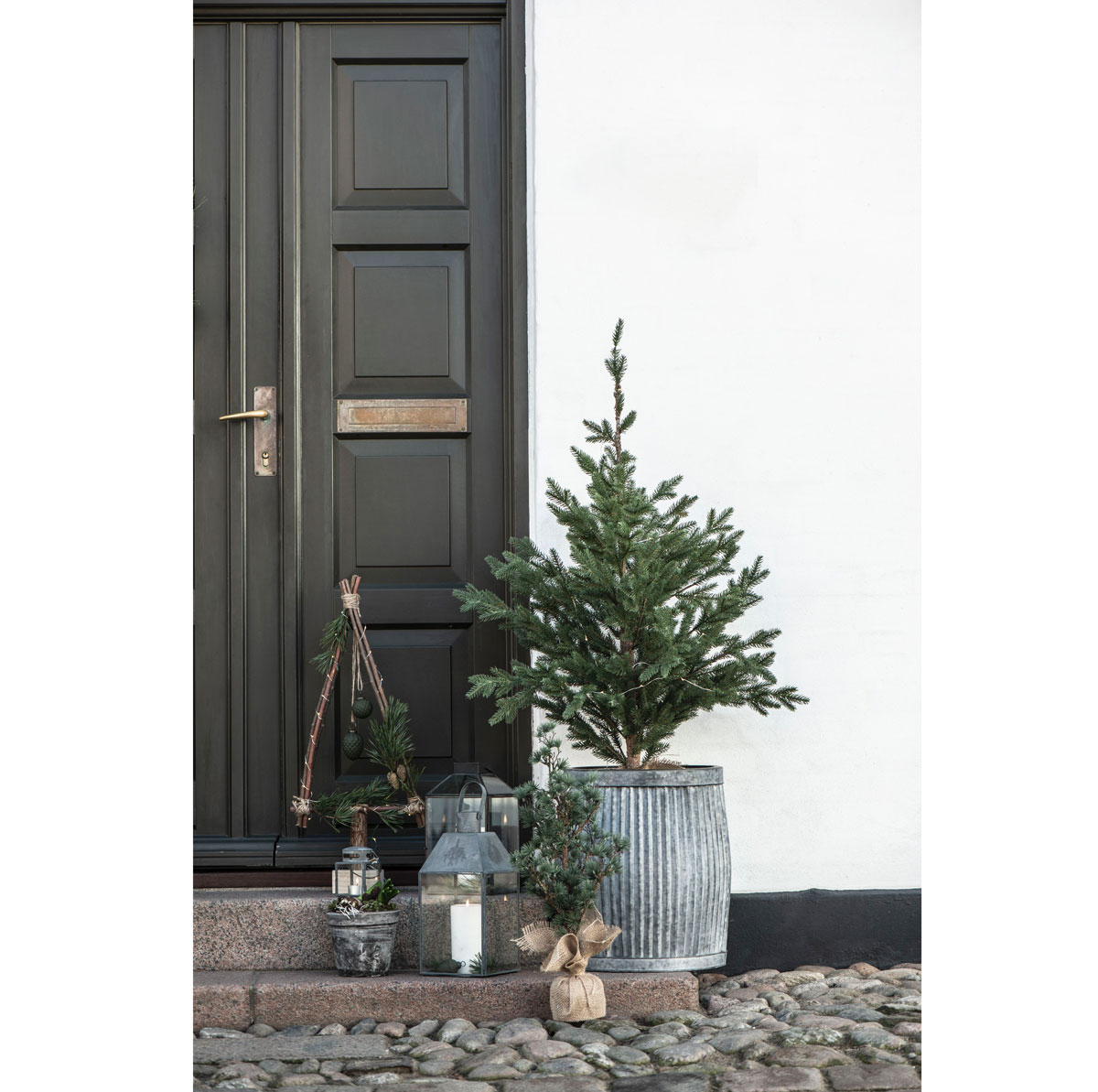 Ihličnatý vianočný stromček pred dverami do domu