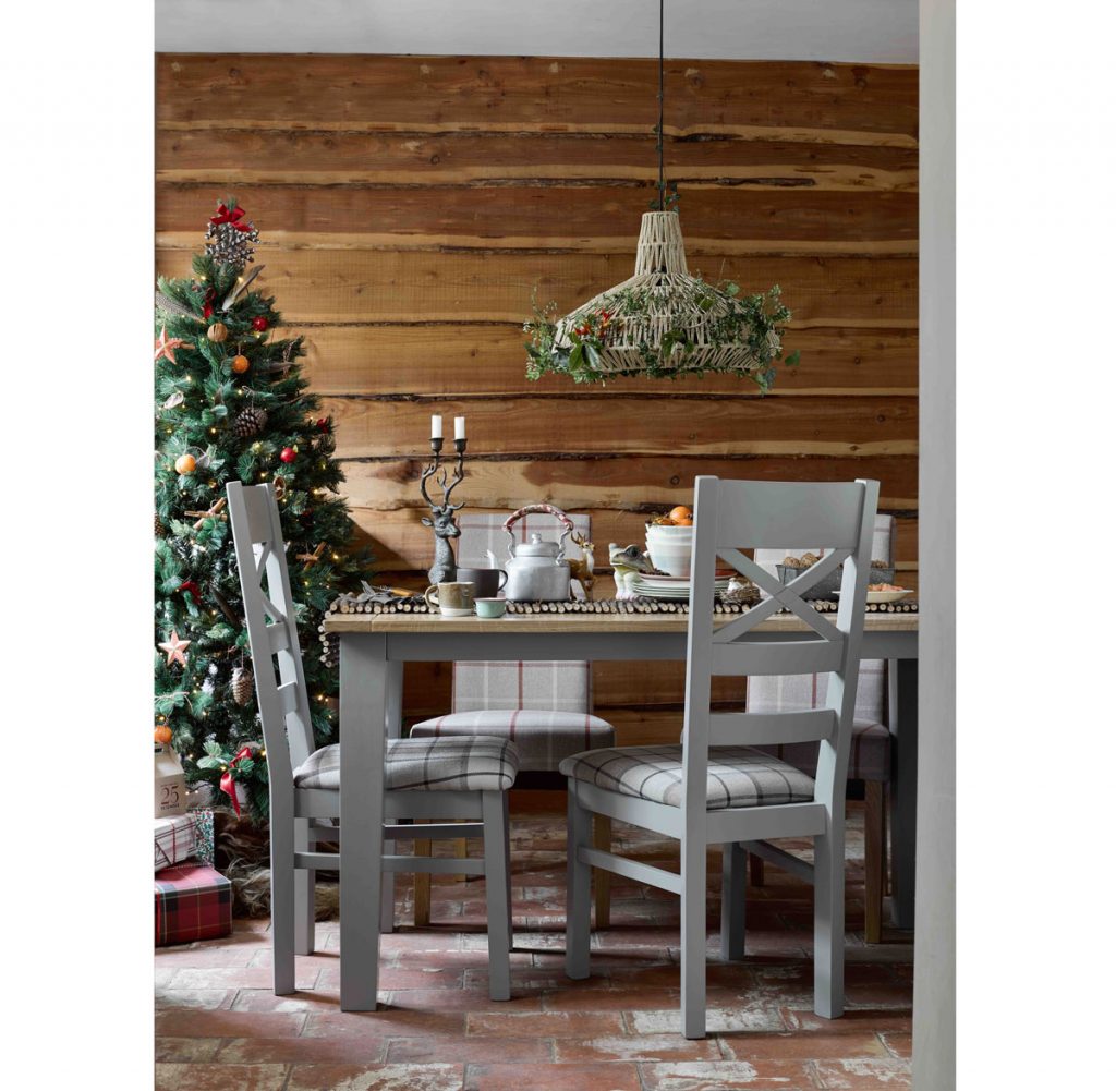 Vianočne vyzdobená jedáleň so stromčekom, zvieracími ozdobami a lustrom s výpletom vyplneným zelenými konárikmi