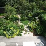 premena malej záhrady: stav po premene, v záhrade je drevená terasa, pôdopokryvné trvalky, chodník z kameňa a dreviny, ktoré zakrývajú výhľad do záhrady