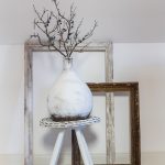 Dekorácie zrecyklovanej vázy natrenej na bielo na drevenej trojnožke, a staré okenné rámy