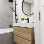 Kúpeľňa v minimalistickom štýle so závesnou umývadlovou skrinkou a dizajnovou čiernou sprchovacou súpravou