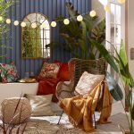 Záhradná obývačková terasa so sedením a farebnými vankúšmi, dekami a zrkadlom
