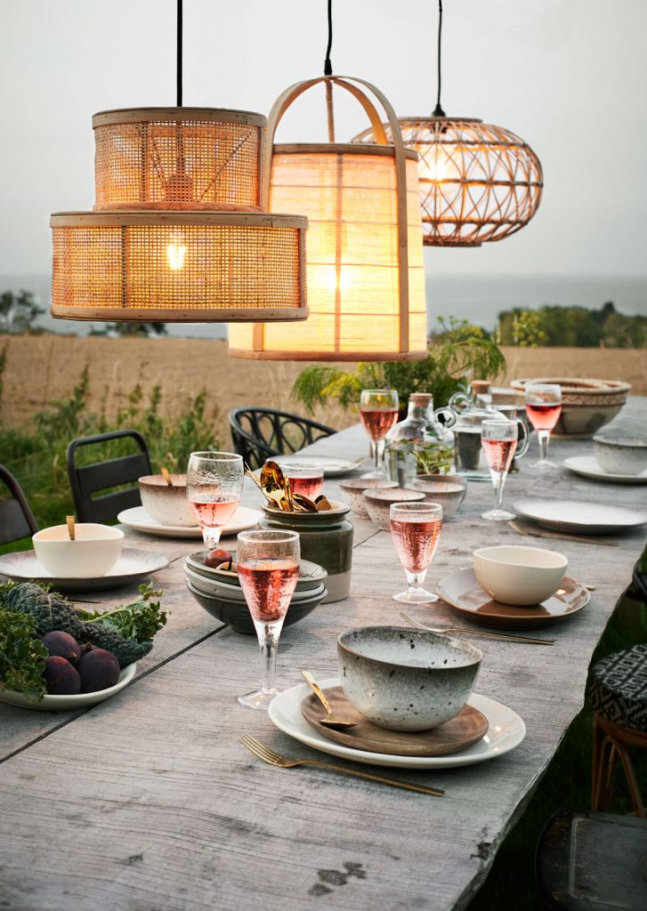 Drevený prestretý jedálenský stôl s vypletanými prírodnými svietidlami