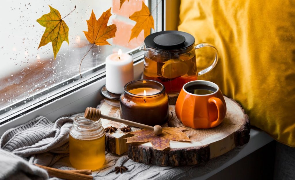 Jesenný aranžmán s čajom a sviečkami na drevenej gulatine