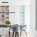 moderný minimalistický interiér s otvorenou knižnicou, ukrytým úložným priestorom a vitrínou vyhotovenými do výšky stropu a s čiernym jedálenským stolom s čalúnenými stoličkami-1
