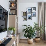 Obývačkova stena v béžovej farbe so skrytými aj otvorenými úložnými priestormi