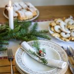 vianočné prestieranie s ihličnatými vetvičkami a starožitnými taniermi po starých rodičoch