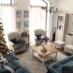 Obývačka s klasickou modrou sedačkou, pásikavými ušiakmi, konferenčným stolíkom, bielymi skrinkami a vianočným stromčekom