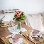 Drevený jedálenský stôl s prestieraním a ružami