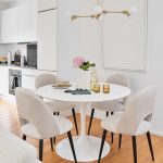 elegantná kuchyňa s jedálňou v bielej farbe, s rohovou kuchynskou linkou a jedálenským stolom so zamatovými stoličkami