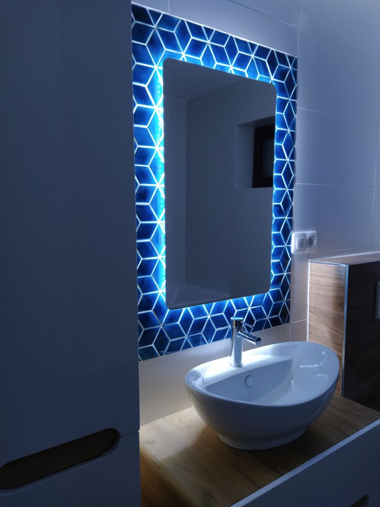 pohľad na umývadlo v kúpeľni s ručne vyrobeným tmavomodrým obkladom a podsvieteným zrkadlom