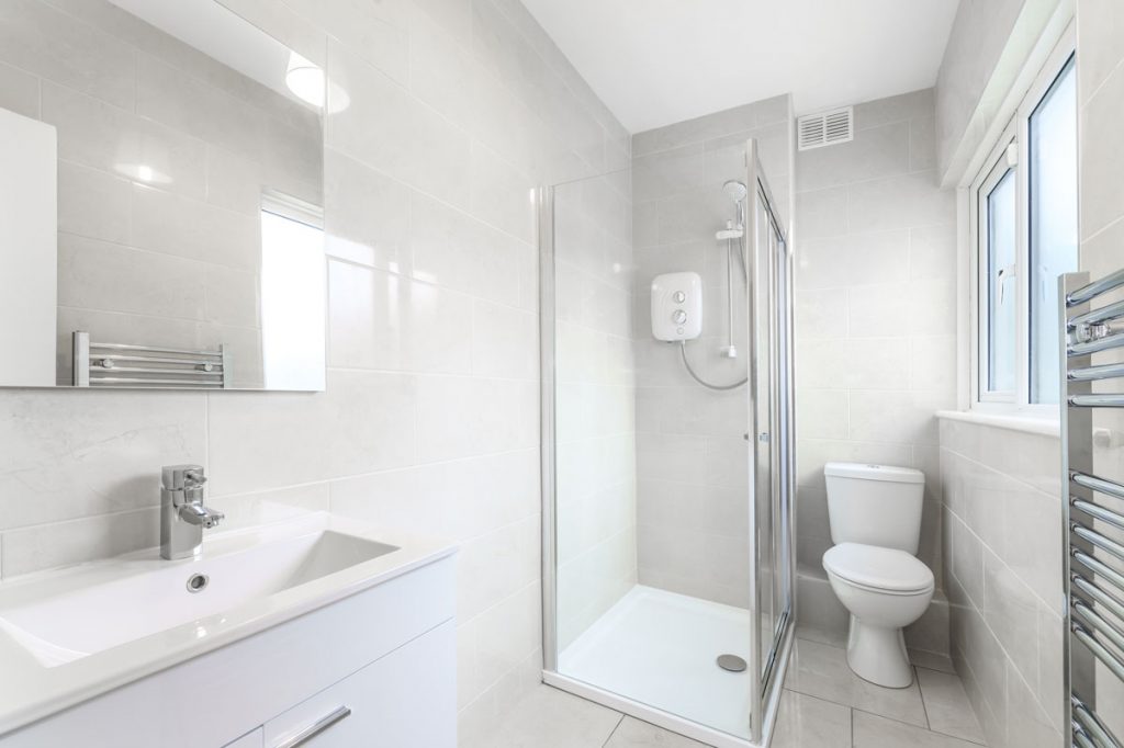 biela kúpeľňa so sprchovým kútom a wc