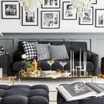 Čierna obývačka v retro a glamour štýle s gaučom, zlatým skleneným konferenčným stolíkom, pufom a taburetmi, zlatým kovovým kreslom, reflektorom a obrazmi starých filmových hviezd