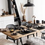 drevený jedálenský stôl, čierne stoličky a lavica a prestieranie v čiernej farbe s čiernymi riadmi