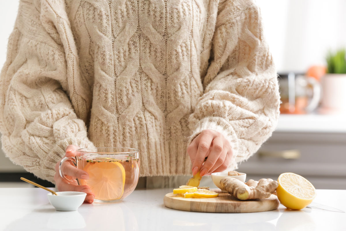 žena pripravuje zázvorový čaj s citrónom