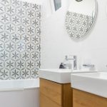 biela moderná kúpeľňa so vzorovaným obkladom a dvomi umývadlami