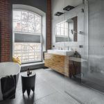 Kúpeľňa v industriálnom štýle s tehlovou stenou, vaňou a sprchovým kútom
