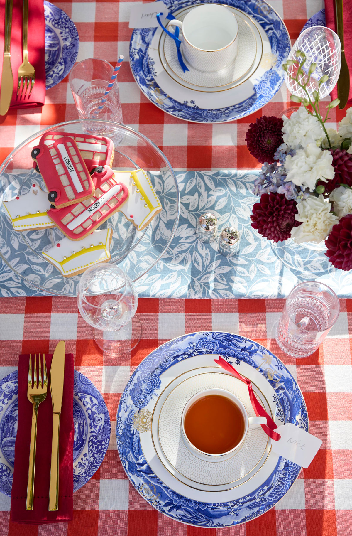 Stôl s červeným károvaným obrusom a modrým riadom