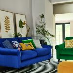 moderná obývačka s výraznou modrou sedačkou a výrazným zeleným kreslom a žltým taburetom, nábytok stojí na pásikavom čierno-bielom koberci