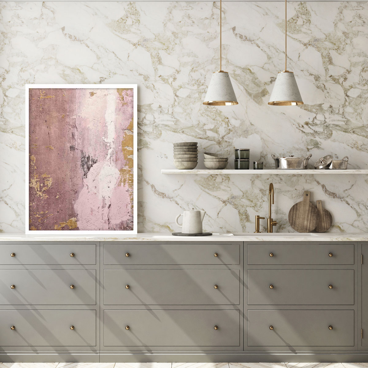 detail kuchyne so zástenou v imitácii mramoru so zlatým žilovaním, na stene je biela polička, o stenu sa opiera ružový abstraktný obraz so zlatými prvkami, spodok kuchynskej linky je sivý so zlatými úchytkami