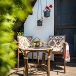 relaxačný kútik na terase malej chalupy, skladá sa z ratanového stolíka a stoličiek
