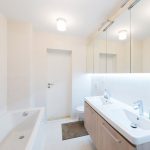 Jednoduchá kúpeľňa v kombinácii bielej a svetlého dreva