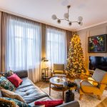 vianočná obývačka v art deco štýle, so sivou koženou sedačkou, halabala kreslami, retro konferenčným stolíkom, art deco doplnkami a vianočným stromčekom, steny sú ozvláštnené lištami