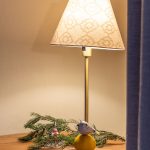 zimný aranžmán pod lampou v podobe ihličnatej vetvičky s vianočnými dekoráciami