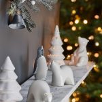 Polička so keramickými ozdobami stromčekov, ľadových medveďov a tučniaka