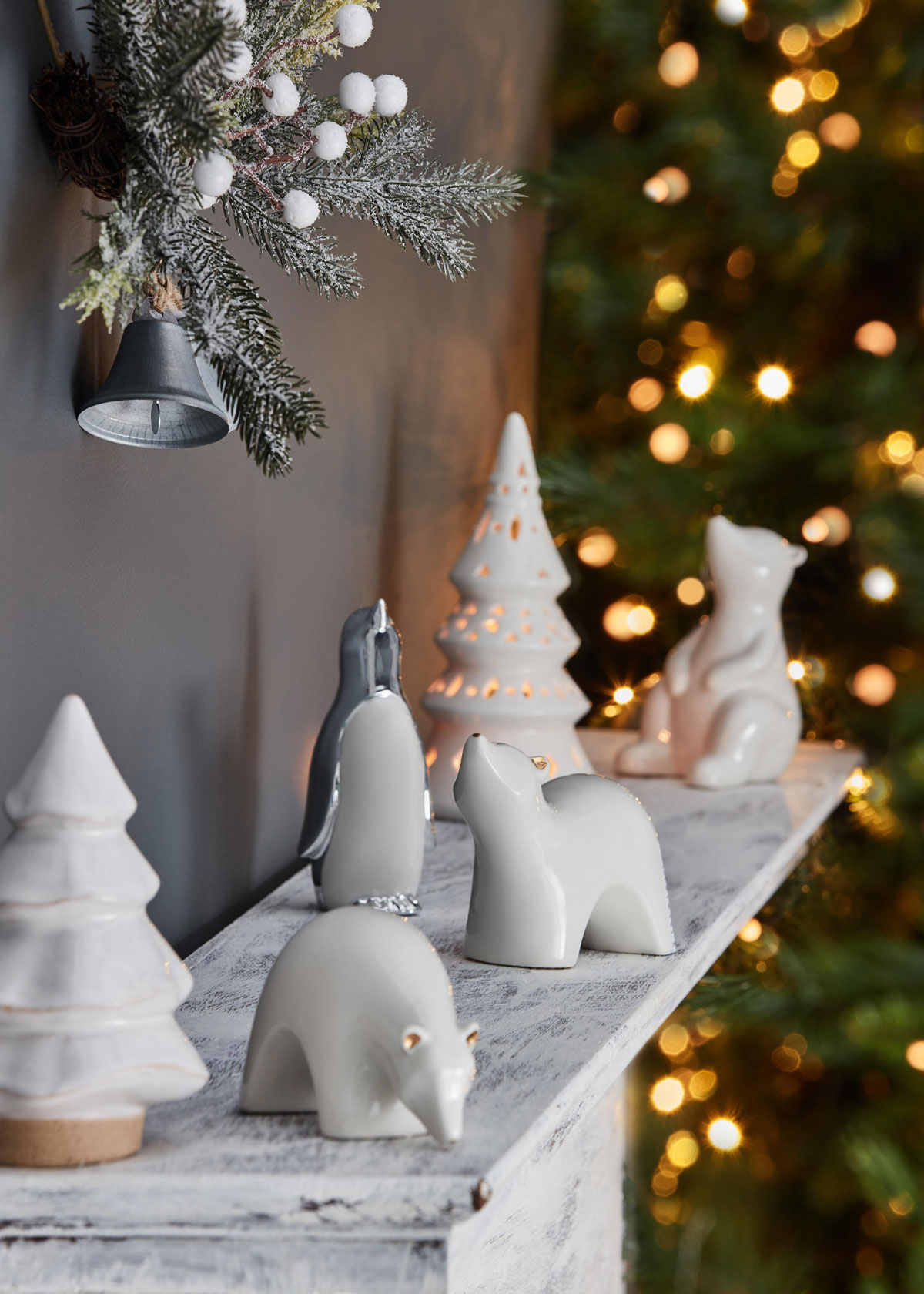 Polička so keramickými ozdobami stromčekov, ľadových medveďov a tučniaka