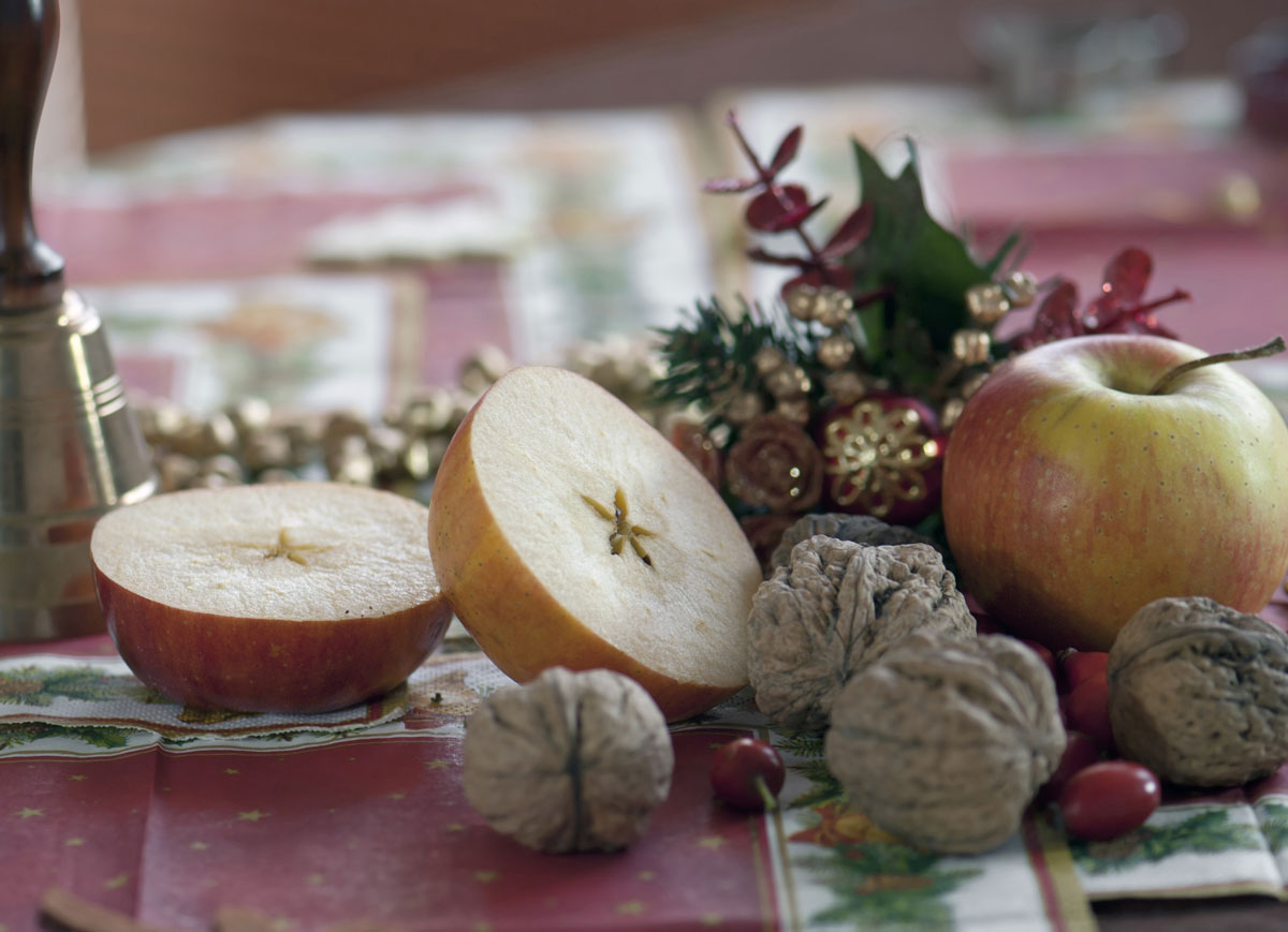 Rozkrojené jablko a oriešky na sviatočnom stole