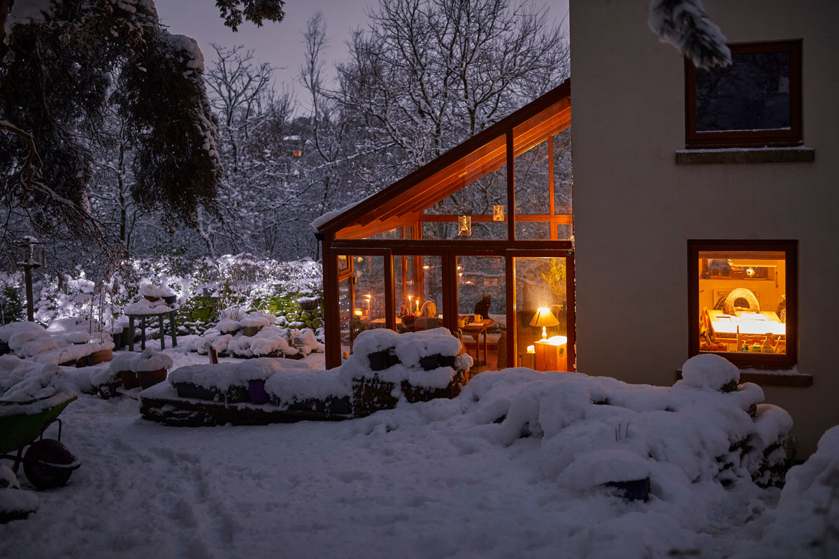 pohľad na rodinný dom so zimnou záhradou zariadenou ako obývačkou