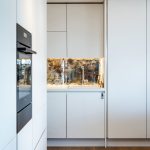moderná kuchynská linka v bielej farbe s antickým zrkadlom ako zástenou