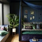 Luxusná spálňa v tmavých farbách modrej a zelenej, posteľ má zamatový baldachýn