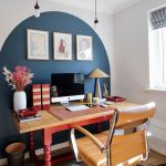 Farebný pracovný kútik s tmavomodrou stenou, hnedočerveným pracovným stolom a hnedou koženou kancelárskou stoličkou