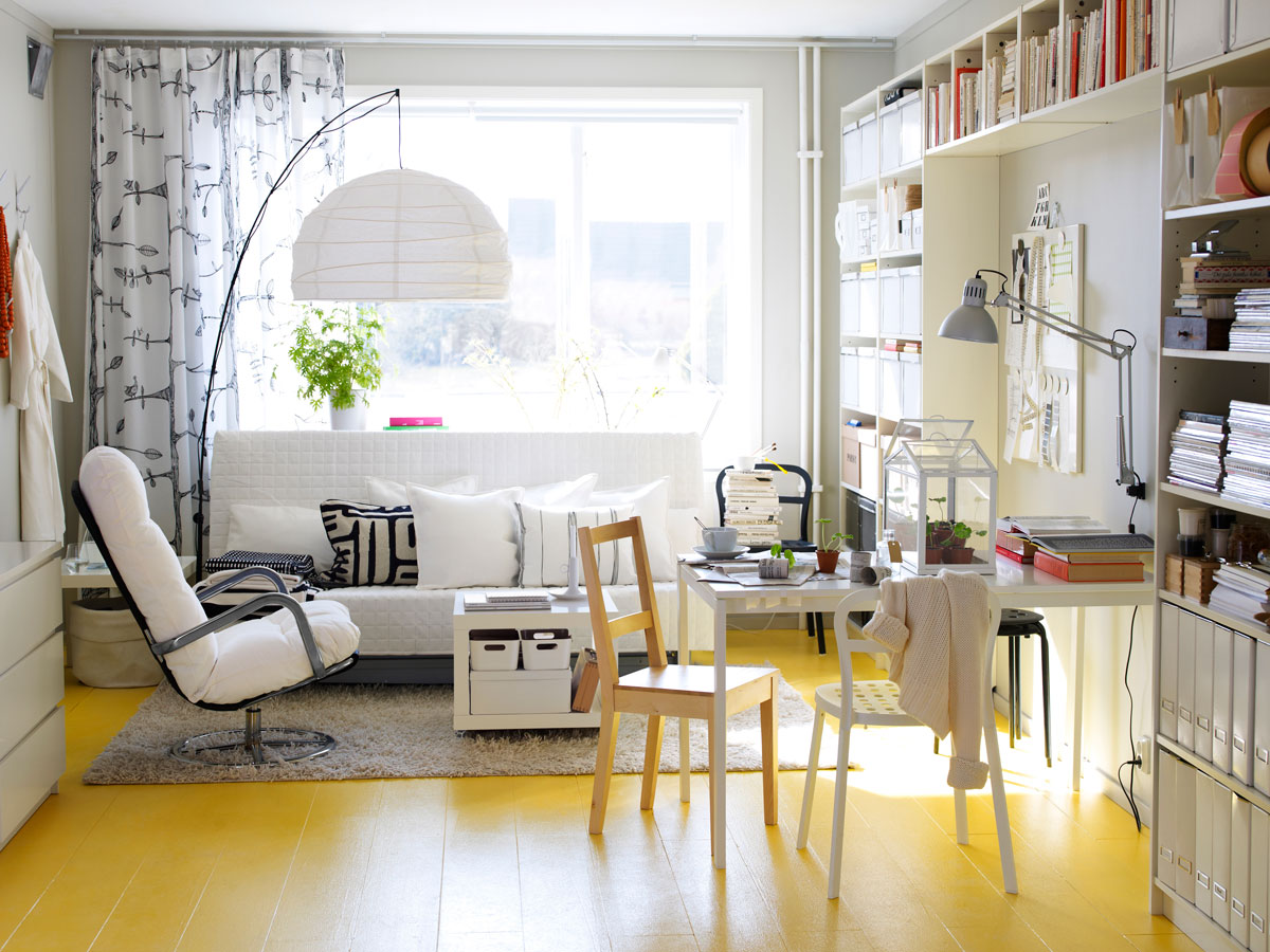 Obývačka spojená s pracovňou, nábytok je bielej farby, farebným prvkom je žltá podlaha
