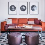 tehlová sedačka v obývačke doplnená o industriálny stolík a fialové taburety