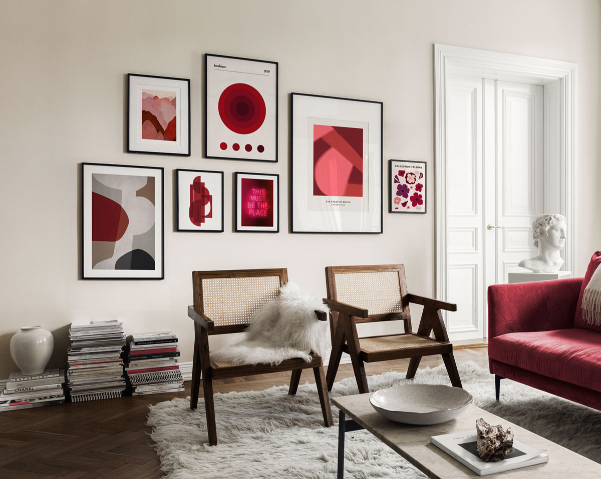 Obývačka s drevenými stoličkami, karmínovou sedačkou, na stene visia obrazy ladené tiež do tohto odtieňa