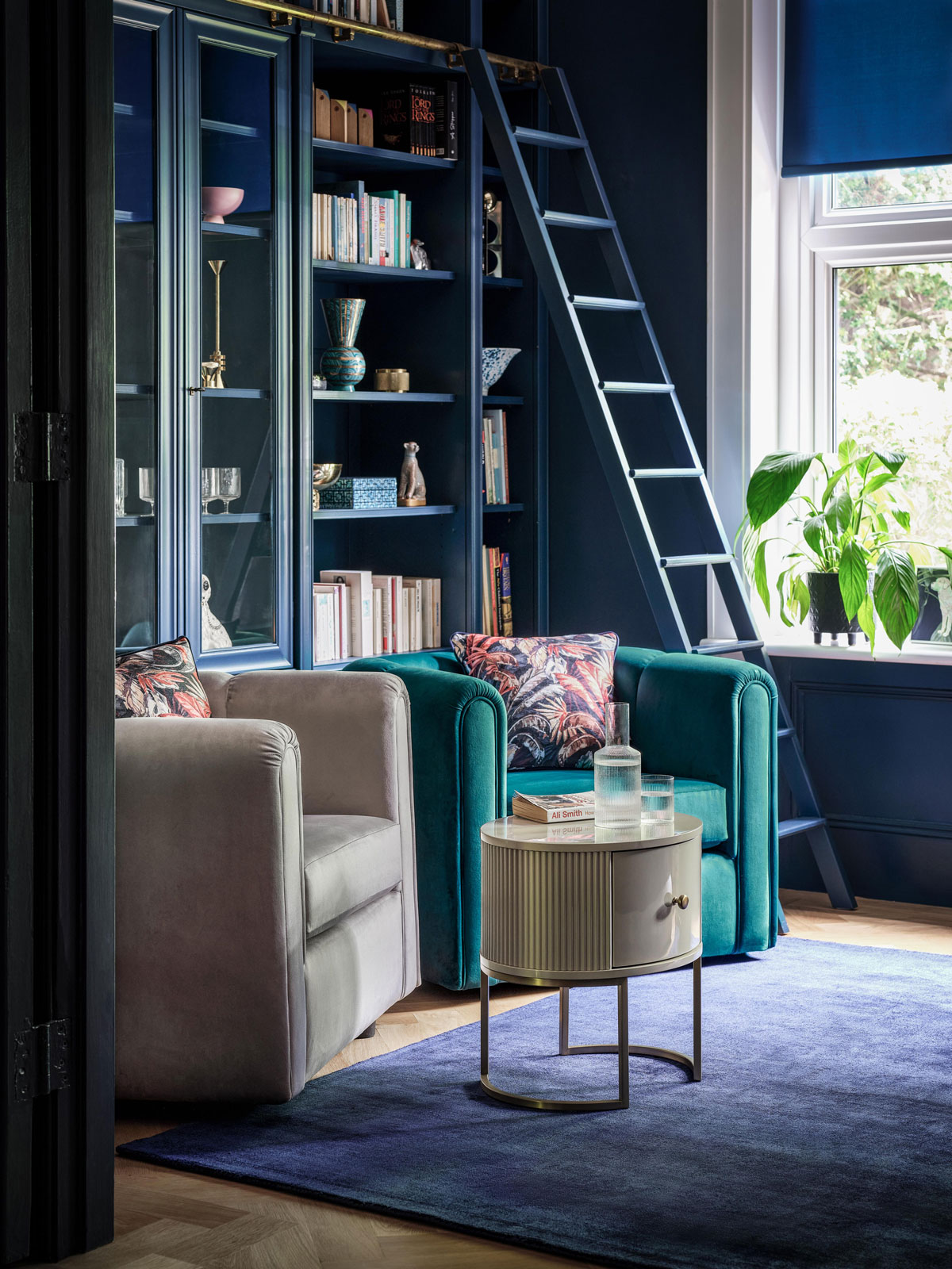 Interiér v odtieňoch modrej, kútik s knižnicou a kresielkami