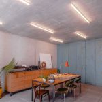 podzemná časť domu zariadená ako spoločenská miestnosť, s modrými drevenými skriňami, retro komodou a stolom