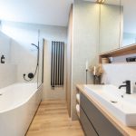 Moderná a elegantná kúpeľňa so sivým obkladom, ladená do neutrálnych zemitých farieb