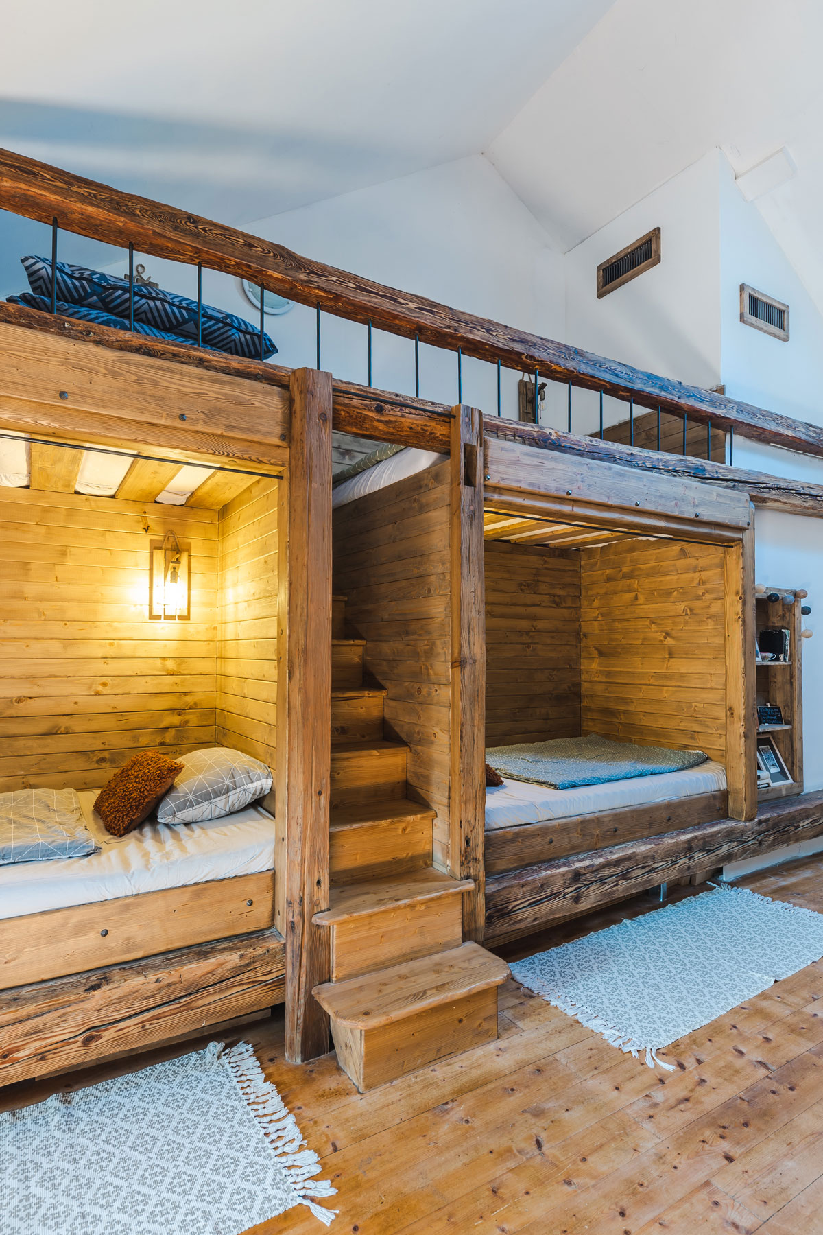 izba s vysokými stropmi a s na mieru vyrobenými poschodovými posteľami z masívneho dreva
