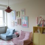 pastelová obývačka s dvoma kreslami v ružovej a modrej farbe, šachovnicovým stolíkom a pastelovou žltou skriňou s veselými dekoráciami