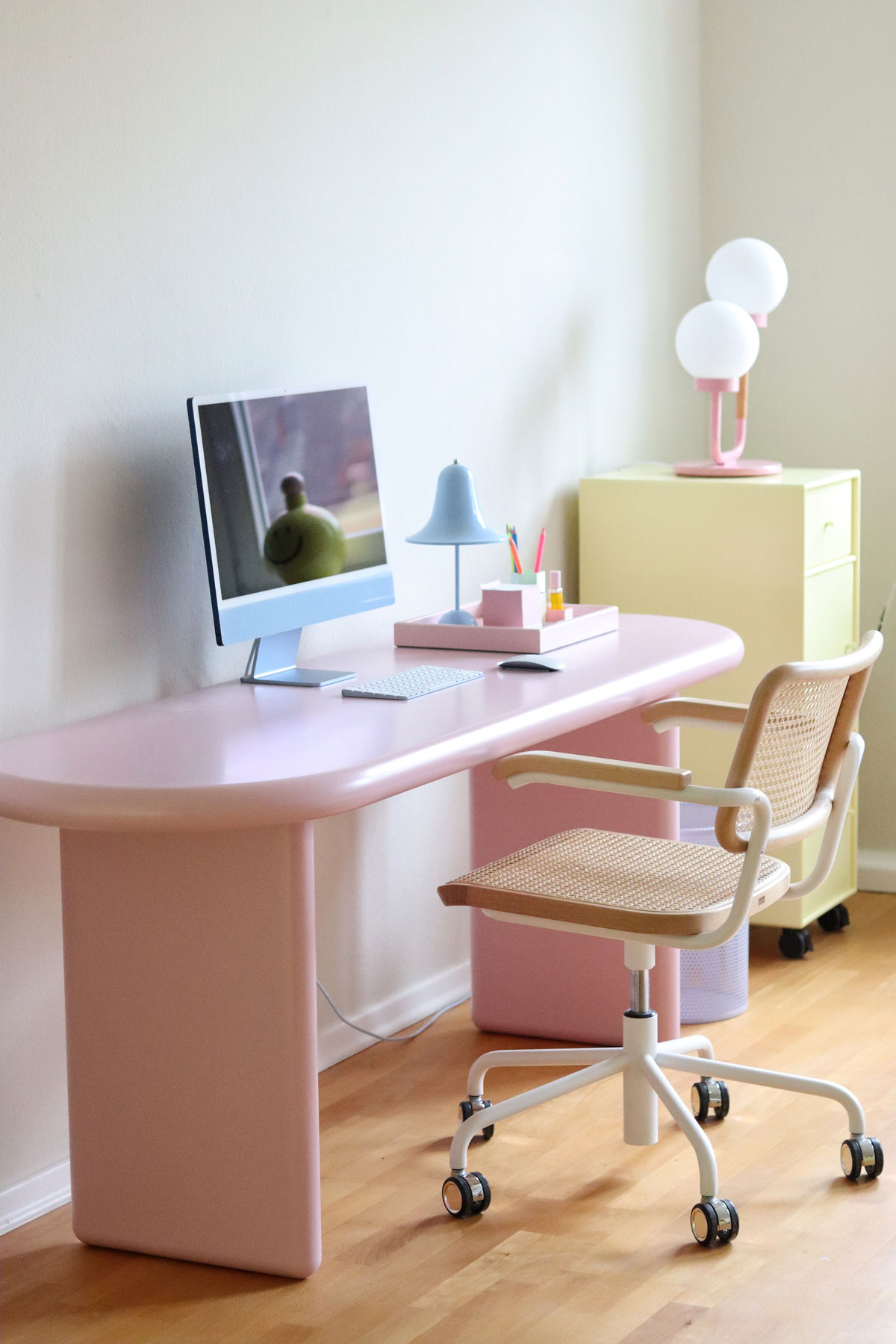pracovňa so stoličkou s viedenským výpletom a pastelovým ružovým pracovným stolom, vedľa neho je žltá skrinka