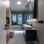 moderná kúpeľňa v kombinácii bieleho obkladu, čiernej a dreva, s podsvietením zrkadla a vane