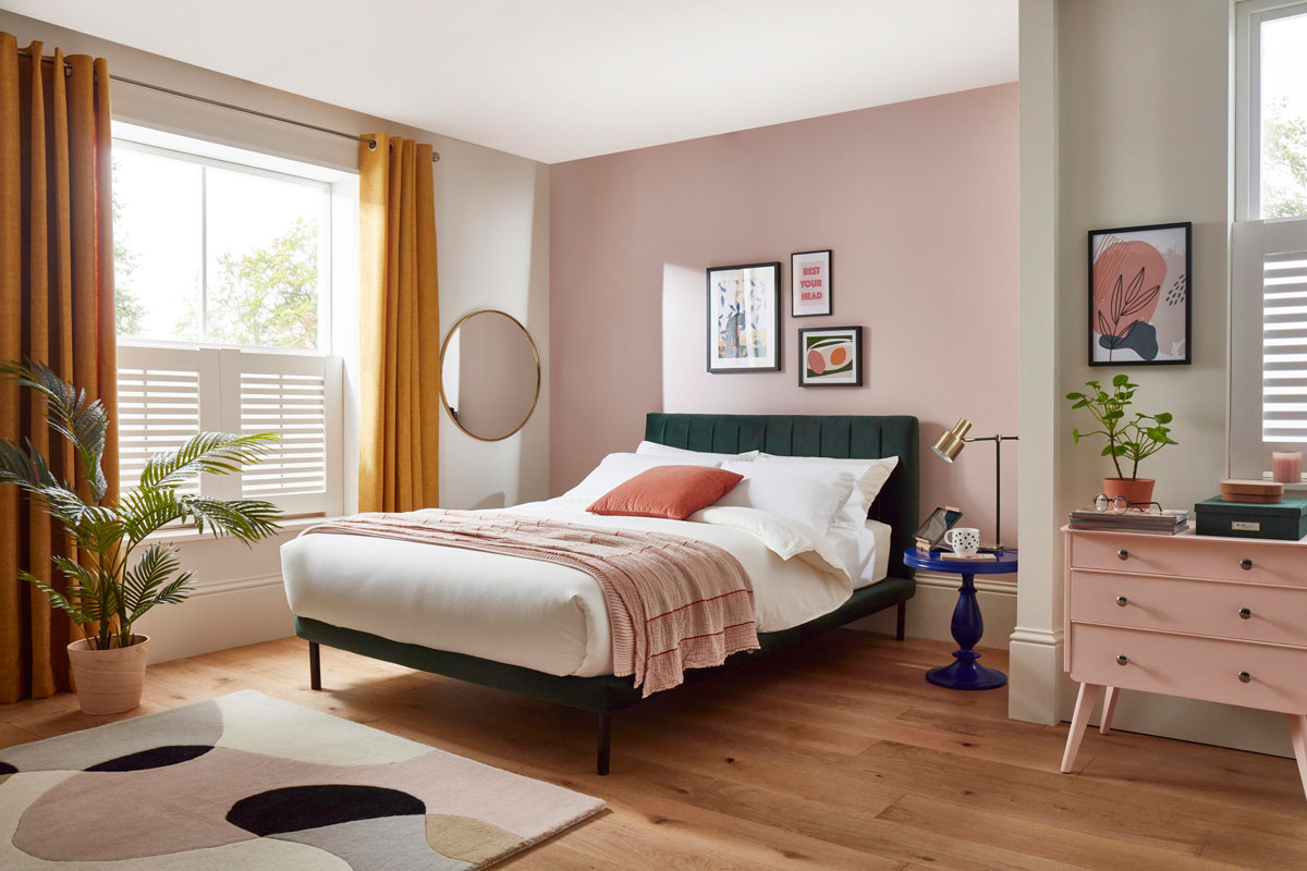 moderná pastelová spálňa s tmavozelenou zamatovou posteľou